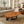 Load image into Gallery viewer, Holzstamm-Tisch aus massiver Akazien-Baumscheibe (114 x 87 x 43 cm, 8 cm starke Platte) in Wassertropfen-Form mit echter Baumkante und sichtbaren Jahresringen, organischer Naturholz-Couchtisch für Wohnzimmer, Loft, Wintergarten oder Empfang in der Schweiz
