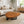 Load image into Gallery viewer, Holzstamm-Tisch aus massiver Akazien-Baumscheibe (114 x 87 x 43 cm, 8 cm starke Platte) in Wassertropfen-Form mit echter Baumkante und sichtbaren Jahresringen, organischer Naturholz-Couchtisch für Wohnzimmer, Loft, Wintergarten oder Empfang in der Schweiz
