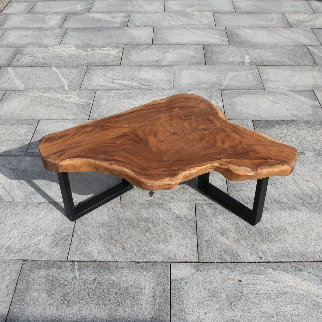 `Couchtisch aus massiver Akazien-Baumscheibe (121 × 80 × 43 cm, 8 cm starke Platte) mit organisch-dreieckiger Form, heller Baumkante und goldbrauner Maserung, Naturholz-Unikat für moderne, skandinavische oder asiatische Wohnzimmer in der Schweiz`
