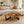 Load image into Gallery viewer, Freiform-Couchtisch aus massiver Akazien-Baumscheibe (120 x 60 x 43 cm, ca. 8 cm starke Platte) mit organischer Naturform, heller Baumkante und sichtbaren Jahresringen, Design-Unikat für stilvolle Wohnzimmer, Lounge oder Leseecke in der Schweiz
