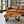 Charger l'image dans la galerie, Rechteckiger Couchtisch aus dunkler Akazien-Baumscheibe (101 x 80 x 43 cm, 8 cm starke Platte) mit naturbelassener Oberfläche, Baumkante, Astlöchern und schwarzen Metallbeinen im Industrial-Stil, Massivholz-Unikat für Wohnzimmercouch, Lounge oder Empfangsbereich in der Schweiz

