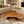 Load image into Gallery viewer, Organisch-dreieckiger Couchtisch aus massiver Akazie-Baumscheibe (96 × 93 × 43 cm, 8 cm starke Platte) mit Baumkante und warmem Goldbraun, Massivholz-Unikat für Design-Wohnzimmer, Loft oder Lounge in der Schweiz
