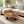 Load image into Gallery viewer, Salontisch aus massiver Akazie-Baumscheibe (95 x 92 x 43 cm, 8 cm starke Platte) mit Naturkante und organischer Form, kompakter Naturholz-Couchtisch im asiatisch inspirierten Stil für kleine Wohnzimmer in der Schweiz
