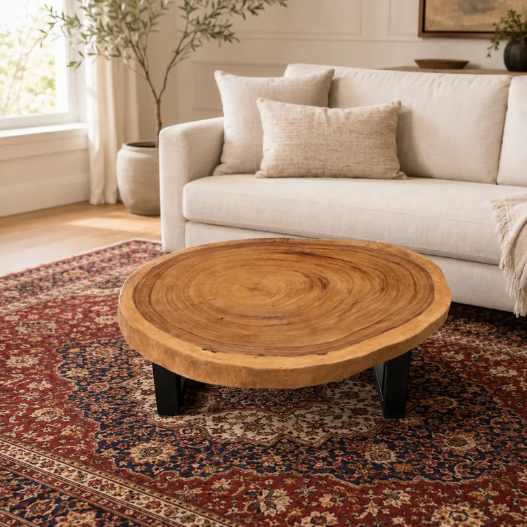 Runder Baumstamm-Couchtisch aus massiver Suarholz-Baumscheibe (92 x 75 x 43 cm, ca. 8 cm starke Platte) mit lebendiger Naturkante und sichtbaren Jahresringen, kompakter Naturholz-Salontisch im asiatisch-rustikalen Stil für Wohnzimmer, Lounge oder Wintergarten in der Schweiz
