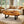 Charger l'image dans la galerie, Ovaler Baumscheiben-Couchtisch aus massiver Akazien-Baumscheibe (120 x 73 x 43 cm, 8 cm starke Platte) mit Naturkante, rustikal-asiatisches Massivholz-Unikat als Wohnzimmertisch für Sofalandschaft, Lounge oder Chalet in der Schweiz
